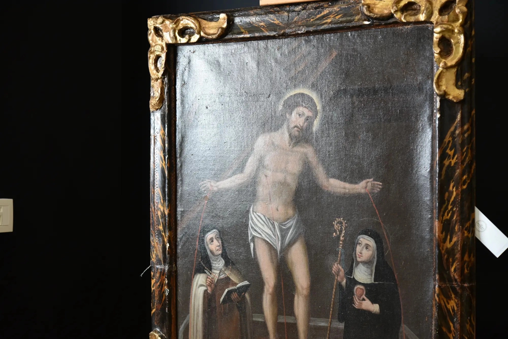 17de-eeuws schilderij van de verrezen Christus met de heiligen Gertrudis en Teresa, met zichtbare vervormingen langs de randen van het doek