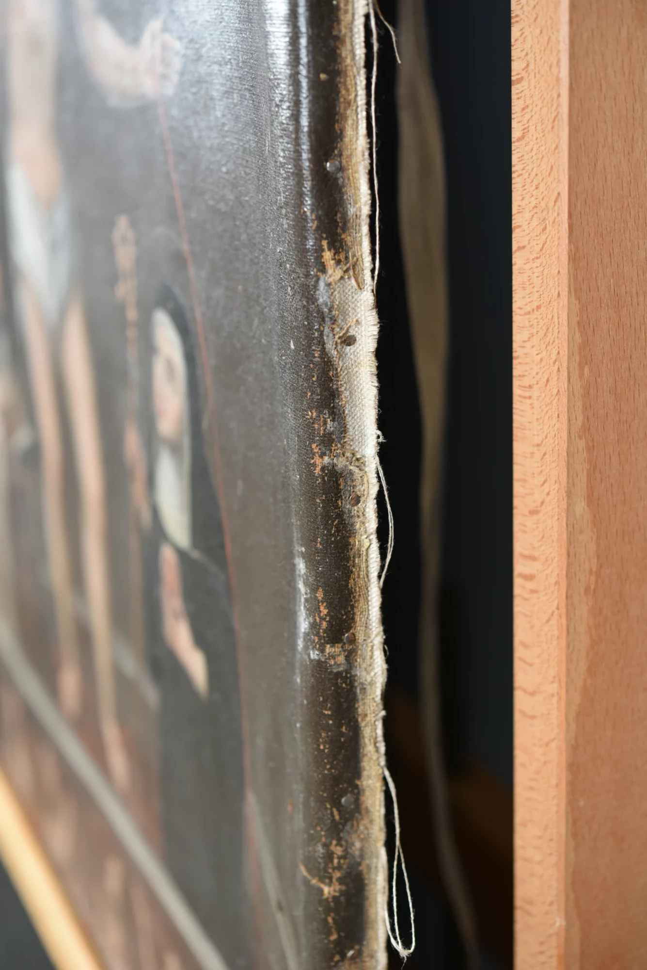 Zijaanzicht van het schilderij met de omgevouwen oorspronkelijke doekrand, zichtbaar tijdens de structurele behandeling.