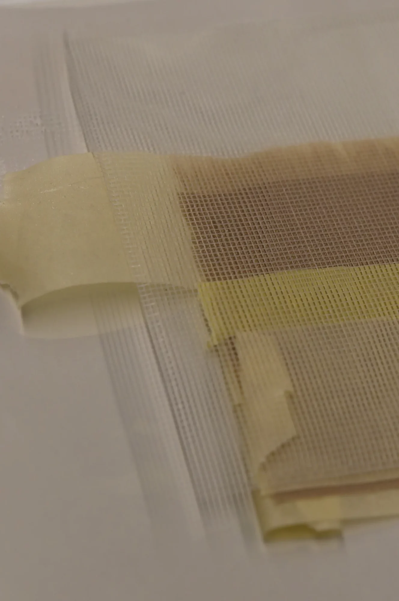 Detail van de nieuwe stripvoering die met de nap-bondingtechniek wordt aangebracht aan de rand van het schilderdoek.