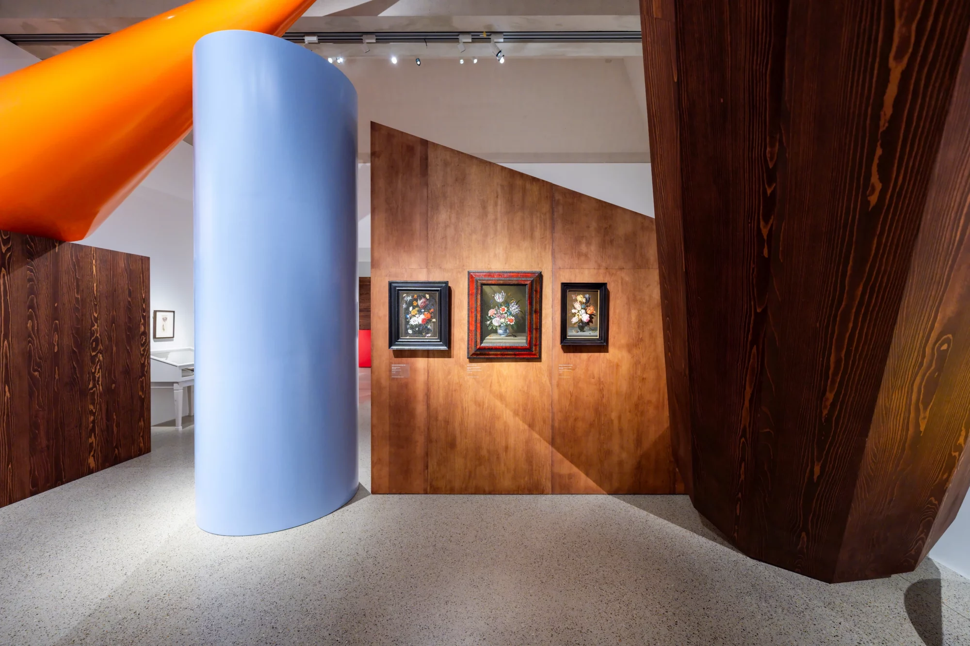 View of the Garden of Delights – The Seventeenth Century in Bloom exhibition at Museum De Lakenhal, with flower still lifes set against monumental wooden walls and colourful scenography by Walter Van Beirendonck.
